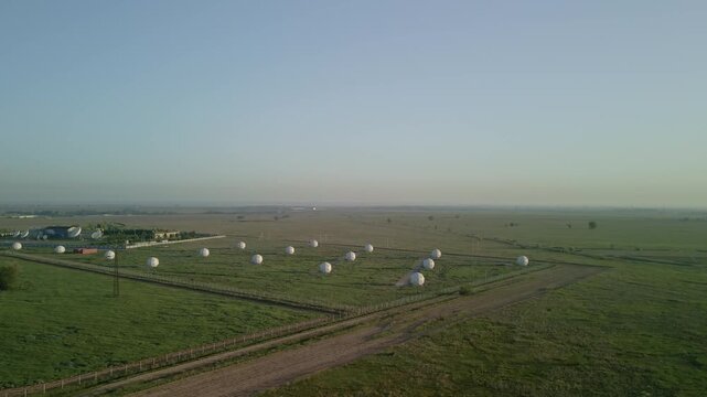 Aerial view of satellite dish station and telecommunication complex in a field. Earth space communication, global network technology and infrastructure drone footage.