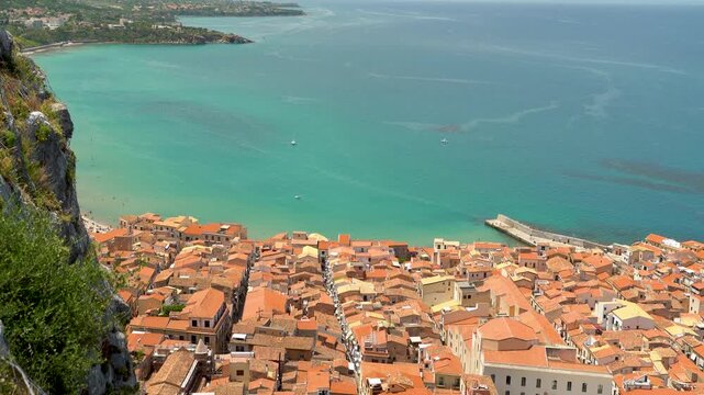 Cefalu &mdash; aerial views from La Rocca cliff fortress over the old town and Tyrrhenian Sea town with terracotta roofs, turquoise Mediterranean waters, and historic architecture overlooking the shoreline