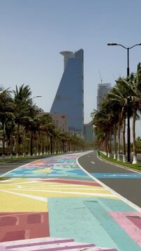 Vertical low angle tracking shot of a colorful pedestrian path leading to Headquarters Business Park tower, Jeddah