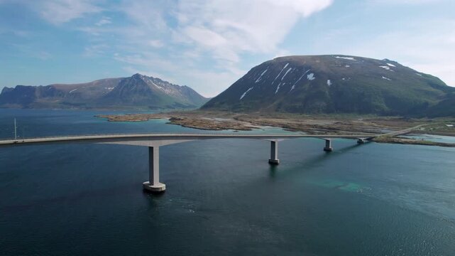 Impressive aerial view of the Gimsoystraume bridge connecting islands in the Lofoten archipelago. Majestic mountains with snow patches in Norway