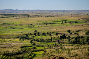 Obraz premium Rural landscape with agricultural fields and scattered trees in the Ihorombe region