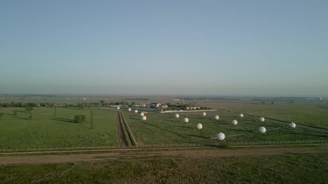 Aerial view of satellite dish station and telecommunication complex in a field. Earth space communication, global network technology and infrastructure drone footage.