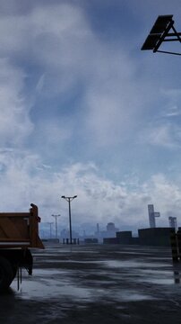 A cloudy sky covers a dock area where cargo containers are stacked. Trucks are parked nearby. The scene shows structures and equipment seen on a working dock at a busy port.