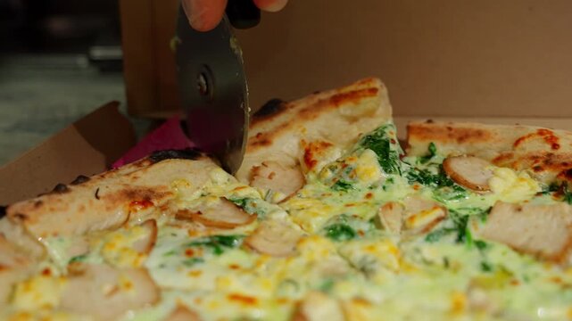 Pizza maker cuts pizza into slices. Pizza making concept.