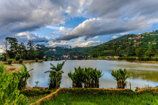 Lake view with lush green vegetation and hills under a cloudy sky in Fianarantsoa