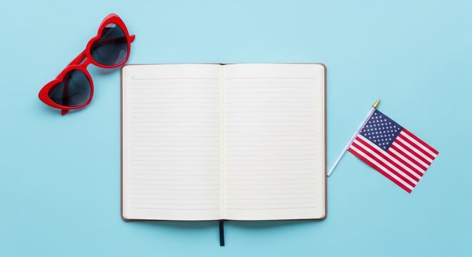 Open Notebook with American Flag and Heart Sunglasses on Blue Background.