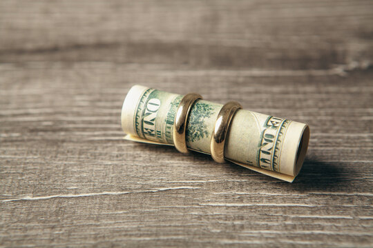 Dollars on a wooden background. Shallow depth of field. Toning with a brocade ring.