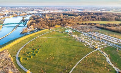 Malowniczy widok z drona na Park 800-lecia Opola i Wyspę Bolko. Zielone tereny rekreacyjne, ścieżki spacerowe oraz rzeka Odra w słoneczny dzień. Pejzaż miejski z góry. © Henryk Niestrój