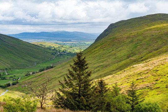 Glengesh Pass winding through a green mountain valley in County Donegal, Ireland. A scenic road landscape of the Wild Atlantic Way and remote Irish highlands.