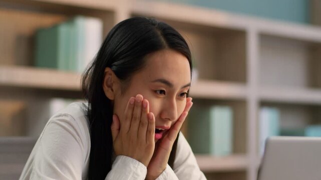Shocked amazed Asian Japanese businesswoman looking laptop suprise wow in office close up female girl Korean ethnic business woman worker computer device gesturing amazement gambling winning indoors