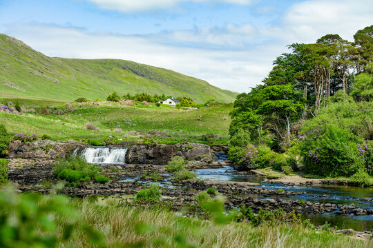 Aasleagh Falls cascades through a rocky river landscape beneath green hills in western Ireland. A scenic freshwater landscape highlighting the natural beauty of the Killary Fjord region.