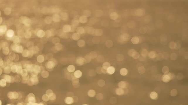 Bokeh sun water shimmering golden light reflecting on sea surface creating a peaceful background atmosphere