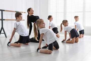 Fototapeta premium Professional dance teacher training children in studio, selective focus