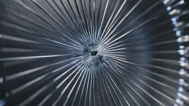 Intricate spiraling metallic structure with radiating lines and a dark central aperture captures attention, suggesting advanced technology and complex engineering principles in a visually