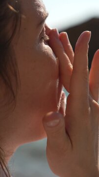 Sunscreen skincare woman applying protective face cream at the beach for healthy skin protection and a radiant summer glow