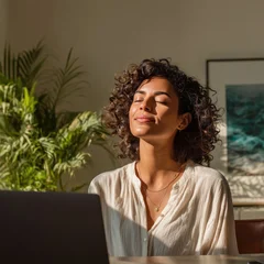 Serene woman enjoying sunlight and a mindful moment at her laptop © pixelliebe