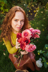 Naklejka premium Redhead Woman Holding Dahlia Bouquet for Emotional Wellness Ritual
