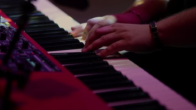 Musician hands playing electronic synthesizer keyboard on stage close up