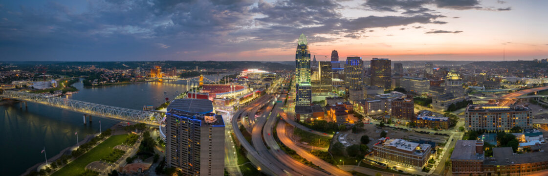 Cincinnati Ohio urban architecture in city downtown at night. Panoramic view of business district skyline with high-rise buildings at nightfall