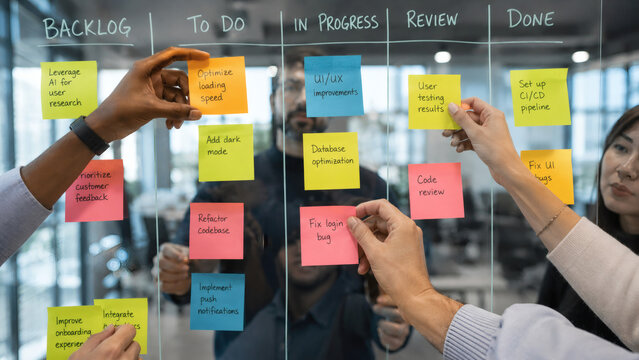 Business team organizing tasks with sticky notes on Kanban board