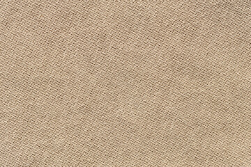 Fototapeta premium Beige woven canvas fabric texture background with diagonal pattern close-up