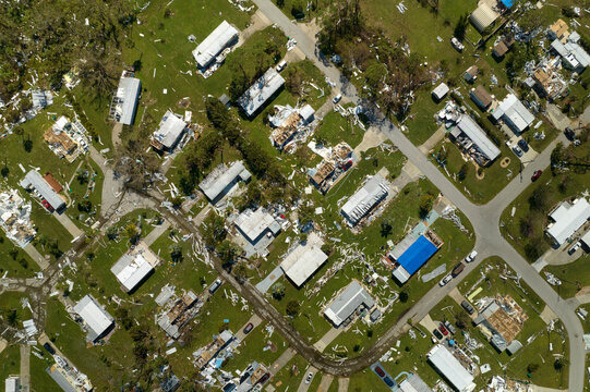 Hurricane destroyed suburban houses roofs in Florida mobile home residential area. Consequences of natural disaster