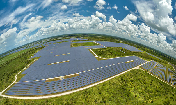 Aerial view of large sustainable electrical power plant with rows of solar photovoltaic panels for producing clean electric energy. Concept of renewable electricity with zero emission