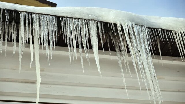 Icicles forming on a roof, symbolizing winter conditions and cold weather elements