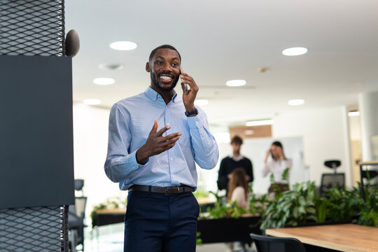 Smiling businessman having phone call in modern office