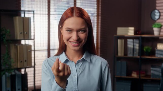 Portrait alluring flirty happy Caucasian business woman showing hey you come here inviting join to work in office smiling girl female businesswoman invite welcome to job flirt looking at camera smile