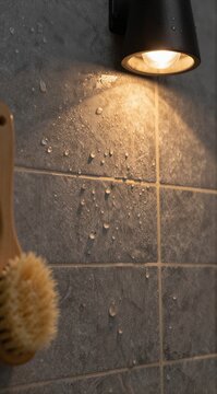 Bathroom tile wall with water droplets under wall light