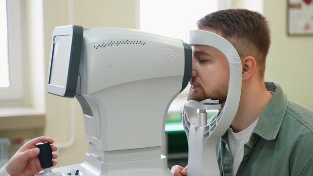 Young man having eye examination with autorefractor keratometer