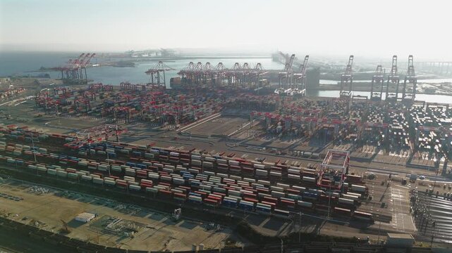 Drone orbit of hazy harbor logistics and cargo terminal at Long Beach port