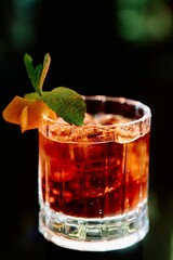 Elegant Red Cocktail with Ice and Mint Garnish in Crystal Glass on Dark Background © Виктор Марчуков