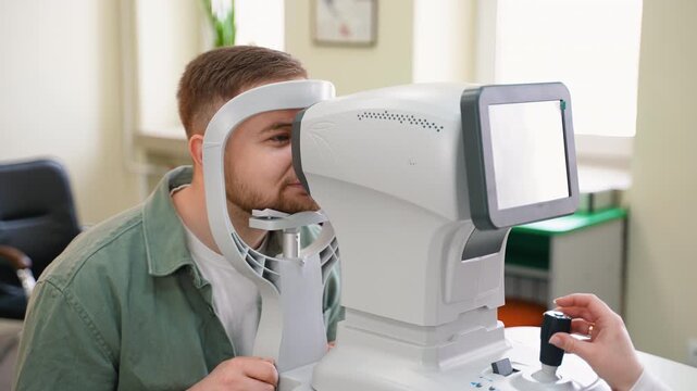 Male patient undergoing eye examination with autorefractor