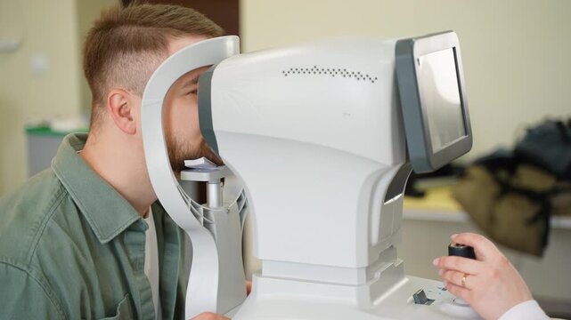 Ophthalmologist performing eye exam using autorefractor machine