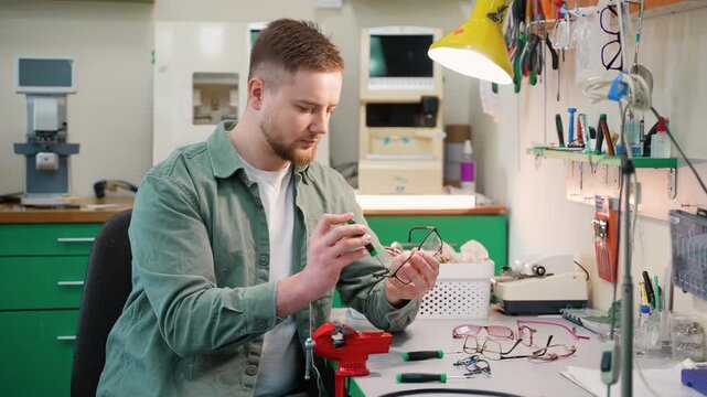 Optician assembling eyeglasses frame in workshop