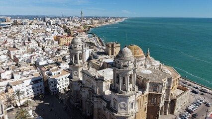 Aerial view of Cadiz Cathedral and its iconic golden dome by the sea. Cinematic drone shot of the historic landmark and the Atlantic Ocean coastline in Andalusia, Spain © Pablohasday