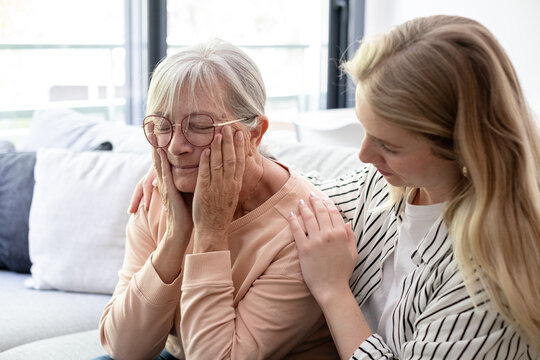 Granddaughter Comforting Elderly Woman At Home Showing Compassionate Family Care And Support
