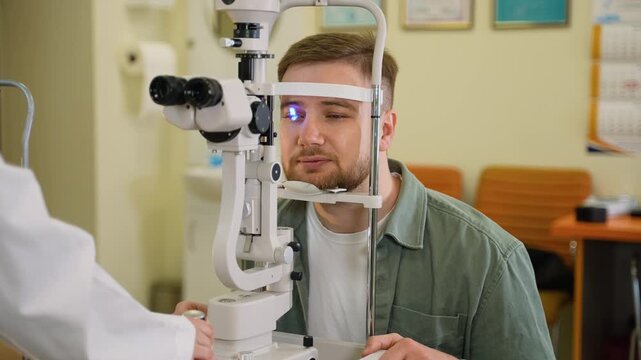 Male patient undergoing eye examination with a slit lamp