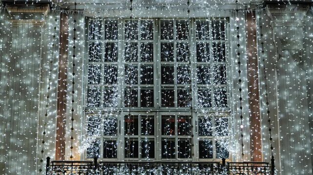Building facade decorated with bright white Christmas string lights for holiday season
