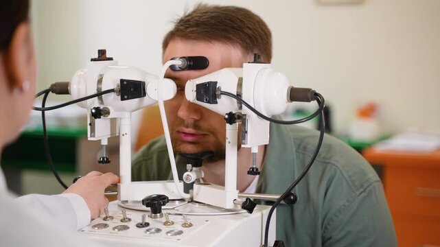 Ophthalmologist checking patient's eyesight with synoptophore machine