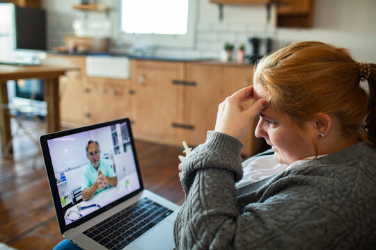 Woman consulting doctor via video call at home