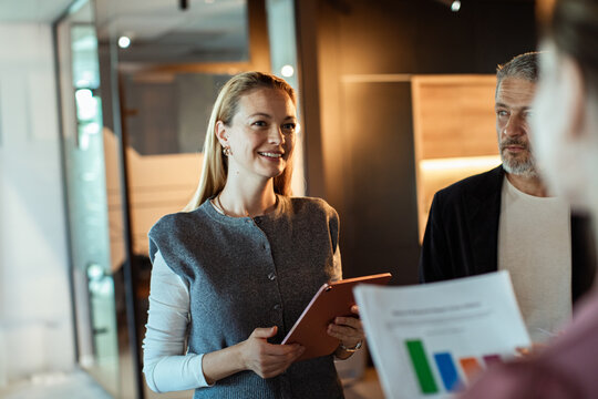Smiling businesswoman leading discussion in modern office