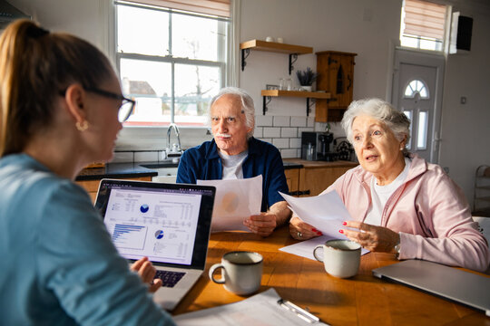 Senior couple meeting financial advisor at home kitchen