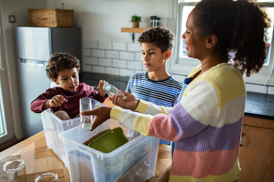 Mother and children sorting recycling in home kitchen