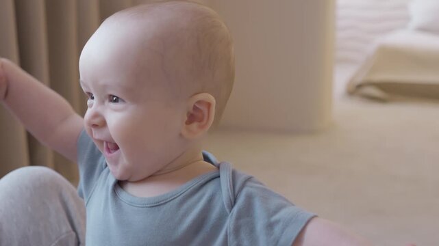 portrait of smiling baby standing on floor with mother nearby, Neutral nursery tones and playful reaching gestures, joyful developmental moment and inquisitive expression