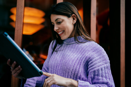 Young woman looking up with smile while working on tablet with electronic pen. Ambition, career goals, and digital transformation. Female expert using modern software for business task, remote life.