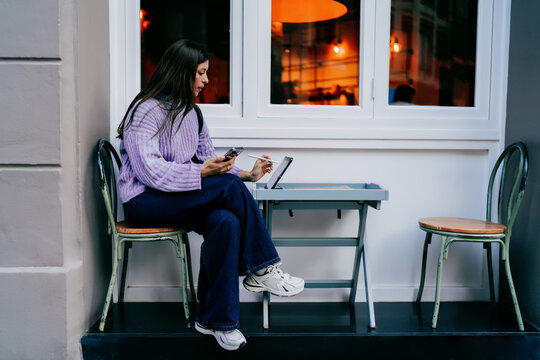 Thoughtful woman looking away holding tablet and electronic pencil. Concept of dreaming, vision, career growth, digital planning. Female freelancer working in modern workspace environment.