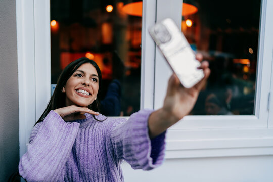 Smiling female user typing on digital tablet with stylus in hand. Financial technology, online banking, data processing or creative editing. Modern professional working in wooden textured office.